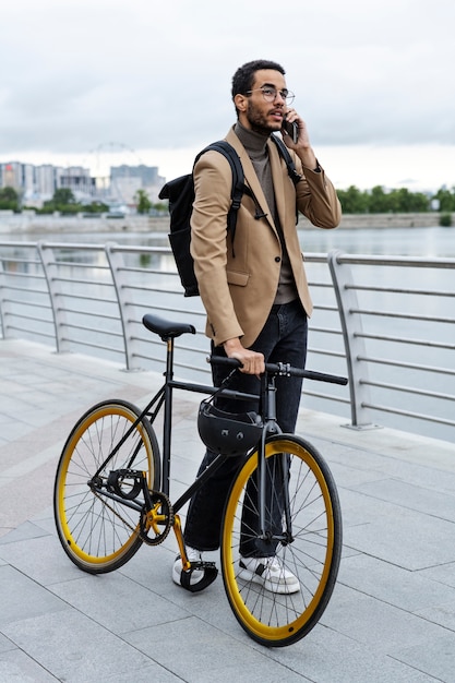 Homem falando ao telefone enquanto segura a bicicleta