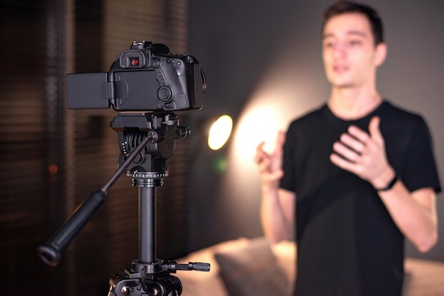 Homem falando para a câmera, gravando a si mesmo em um vlog. Trabalhando em casa. Jovem criador de conteúdo