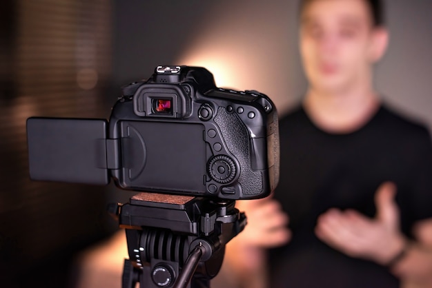 Homem falando para a câmera, gravando a si mesmo em um vlog. Trabalhando em casa. Jovem criador de conteúdo