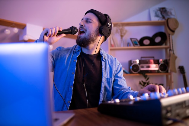 Foto grátis homem fazendo música em casa vista frontal
