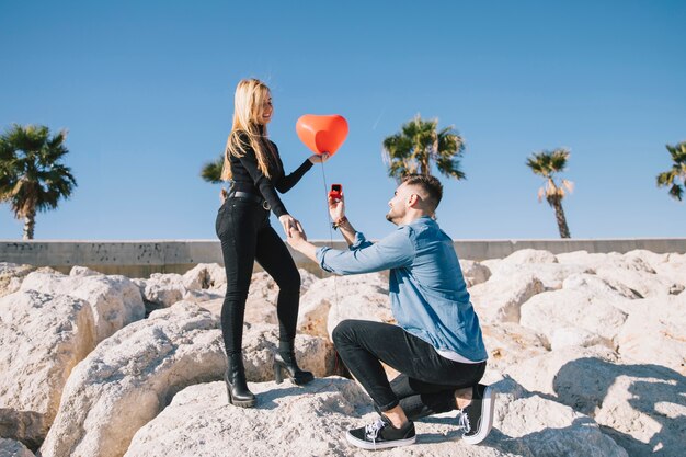 Homem fazendo proposta para namorada na costa