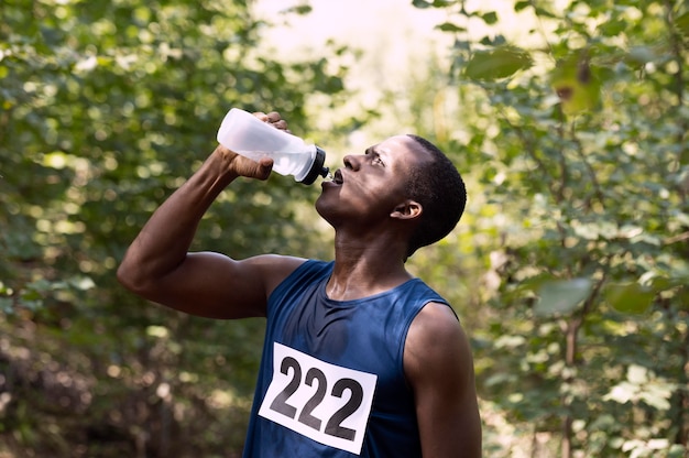 Homem fazendo uma pausa na corrida para beber água