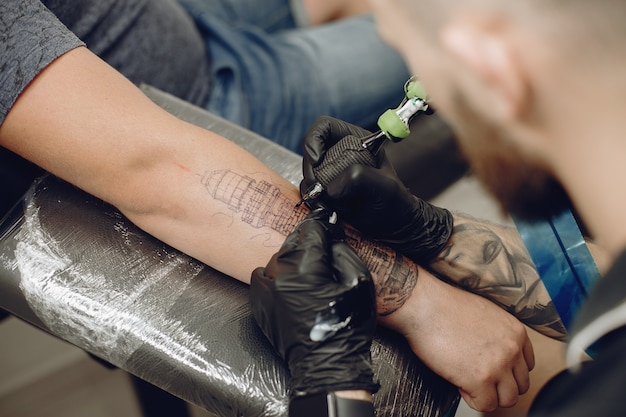 Homem fazendo uma tatuagem em um salão de tatuagem