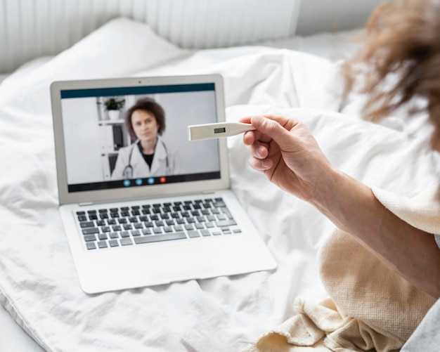 Foto grátis homem fazendo uma videochamada com um médico