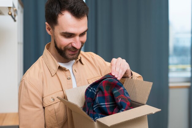 Homem feliz, abrindo o pedido on-line