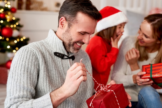 Homem feliz abrindo presente de Natal