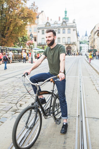 Homem feliz com a bicicleta na cidade