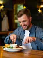 Foto grátis homem feliz comendo tiro médio