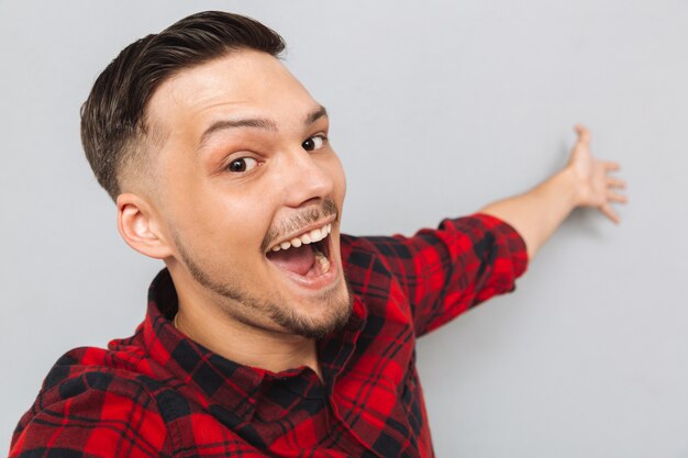 Homem feliz, de pé para o lado e posando no estúdio