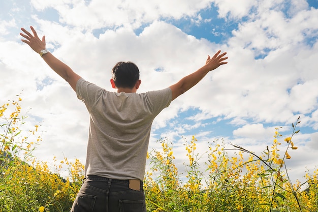 Homem feliz, em, natureza, de, amarela, campo, flor, e, céu branco brilhante, nuvem