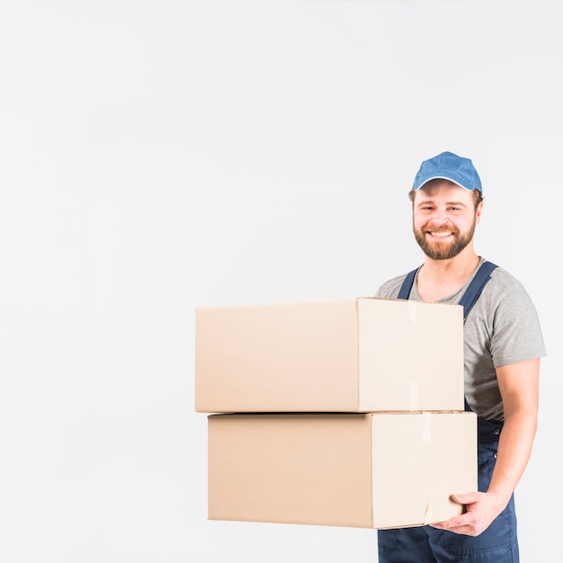 Foto grátis homem feliz entrega permanente com grandes caixas