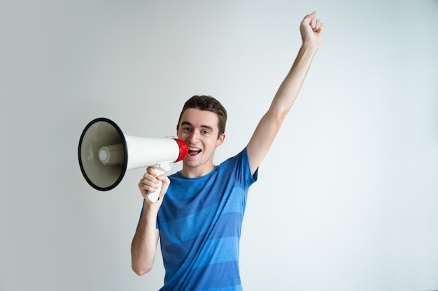Foto grátis homem feliz falando no megafone e levantando o braço