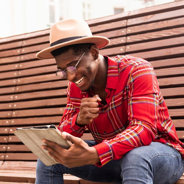 Homem feliz lendo em seu tablet digital