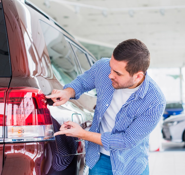 Homem feliz na concessionária de carros