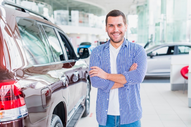 Foto grátis homem feliz na concessionária de carros