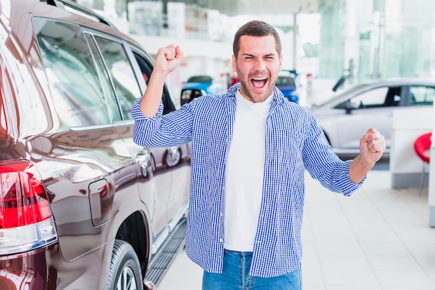 Foto grátis homem feliz na concessionária de carros