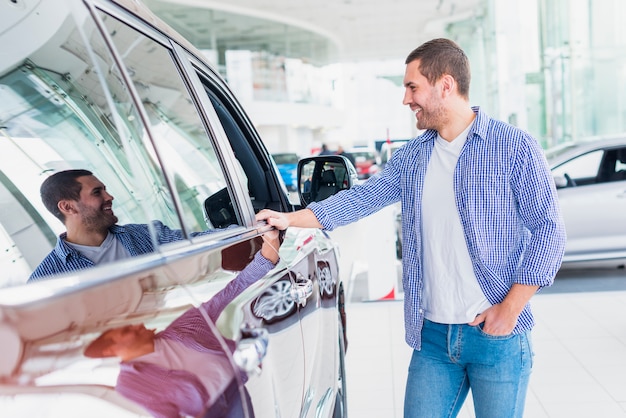 Homem feliz na concessionária de carros