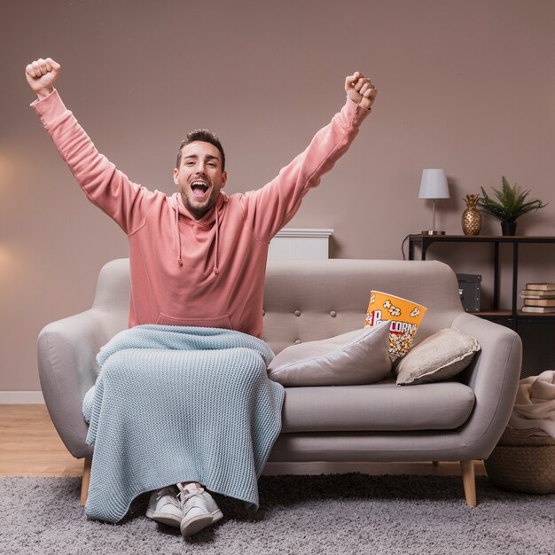 Homem feliz no sofá em casa