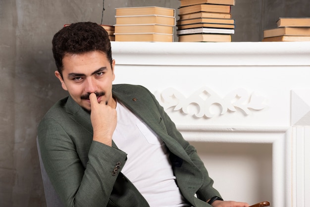 Homem feliz posando com lareira e livros