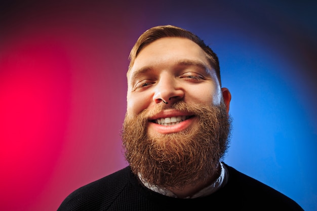 Homem feliz que está e que sorri isolado no estúdio cor-de-rosa.