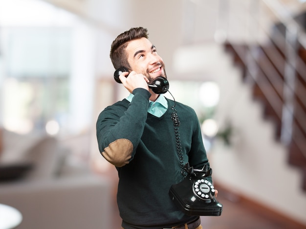 Homem feliz que fala em um telefone antigo