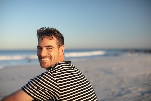 Homem feliz relaxante na praia