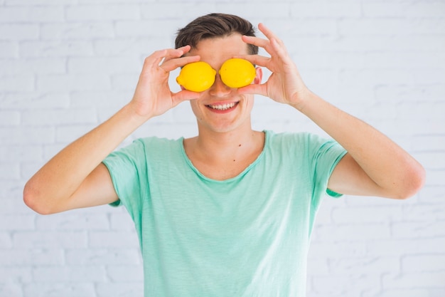 Foto grátis homem feliz, segurando, inteiro, limões, frente, seu, olhos