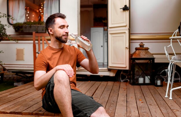 Homem feliz sentado a beber uma bebida