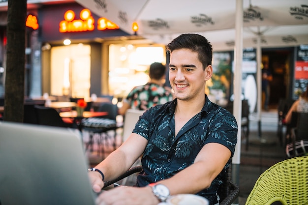 Homem feliz trabalhando no laptop