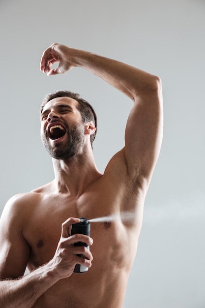 Foto grátis homem feliz usando desodorante