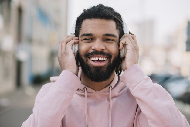 Homem feliz usando fones de ouvido tiro médio