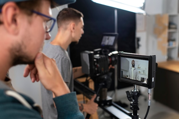 Foto grátis homem filmando com uma câmera profissional para um novo filme