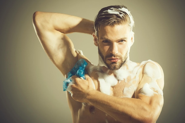 Homem forte sexy nu bonito, fisiculturista tomando banho após o treino. o homem recebe um banho relaxante após um dia difícil. Foto Premium