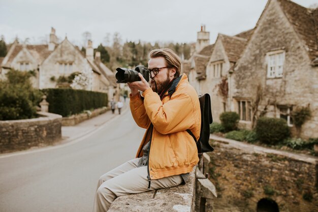 Homem fotógrafo tirando fotos na vila em Cotswolds, Reino Unido