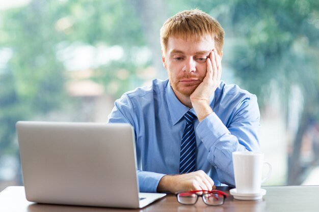 Homem furado olhando para um laptop