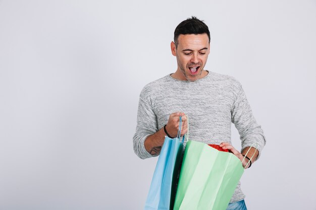 Homem gritando com sacolas de compras