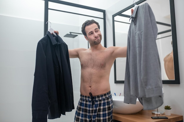 Homem hesitando que camisa escolher