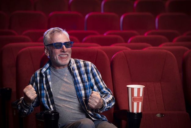 Homem idoso assistindo filme no cinema