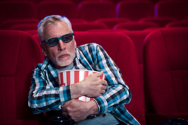 Homem idoso assistindo filme no cinema