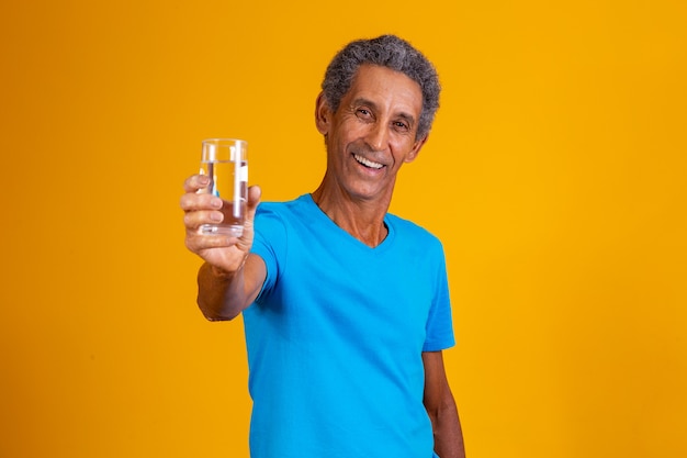 Homem idoso bebendo água para hidratar. homem idoso segurando um copo d'água