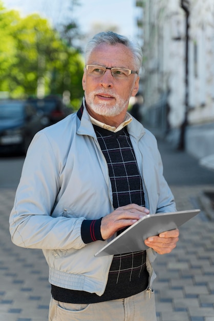 Homem idoso de tiro médio com tablet