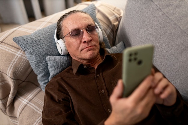 Homem idoso de tom médio com fones de ouvido