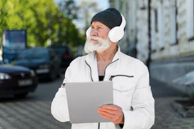 Homem idoso em foto média usando fones de ouvido