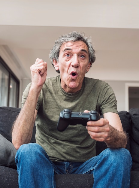 Foto grátis homem idoso feliz jogando videogame