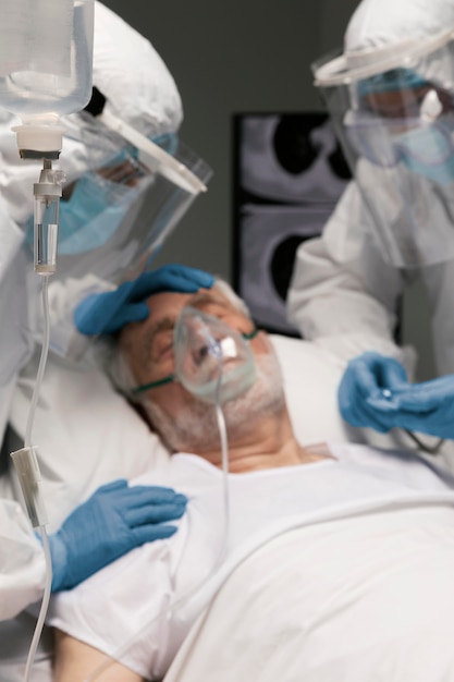 Homem idoso respirando com um equipamento especial no hospital