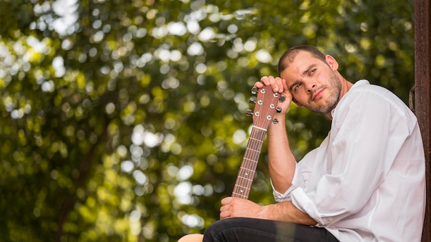 Homem inclinando a cabeça no espaço da cópia do cabeçote da guitarra