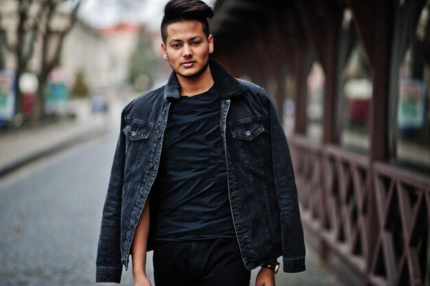 Homem indiano bonito e elegante na jaqueta jeans preta posou ao ar livre