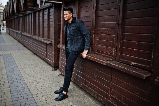 Homem indiano bonito e elegante na jaqueta jeans preta posou ao ar livre