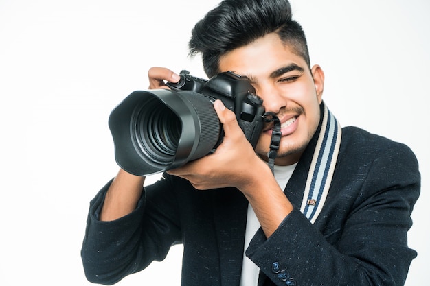 Homem indiano do fotógrafo segurando sua câmera em um fundo branco.