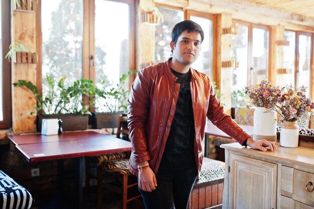 Homem indiano elegante em roupas casuais posando café interior